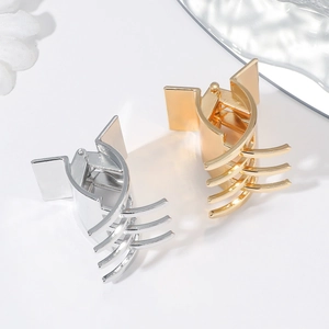 Detailed view of elegant gold and silver metal hair claws with geometric curved design