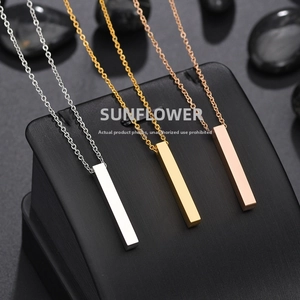 Detailed view of silver, gold, and rose gold bar pendant necklaces on black stones