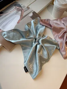 Detail of satin scrunchies with pearly luster and Hand Made label on fabric