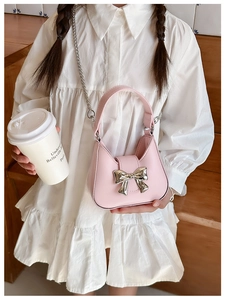 Girl in white dress holding pink PU leather bag with silver bow and chain strap
