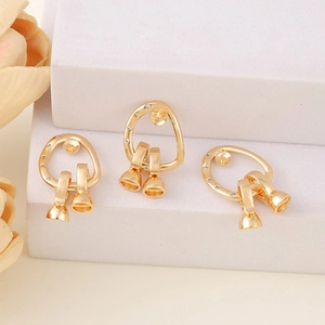 Macro shot of gold DIY jewelry components with zircon stones and bell-shaped charms