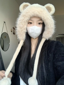 Detail of plush off-white bear ear hat with long faux fur texture and earflaps