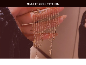 Detail of gold star tassel earrings with long chains and sparkling rhinestones