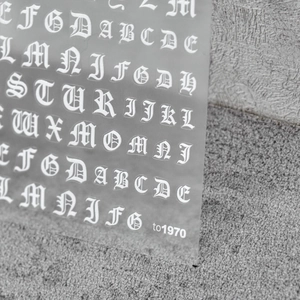 Close-up of white gothic alphabet nail art stickers for DIY manicure decoration