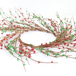 Artificial Christmas berry wreath with red berries and green foliage on white marble