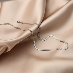 Macro detail of silver stainless steel snake chain necklace with lobster clasp