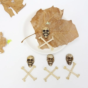 Beige Halloween skeleton skulls and bones on white plate with brown dried leaves