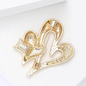 Detailed back view of a golden heart brooch showing the pin clasp and metal texture