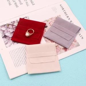 Flat lay of macaron-colored suede jewelry envelopes in red, purple, and apricot tones