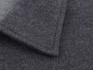 Macro shot of dark grey twill fabric texture and tailored collar on the jacket suit