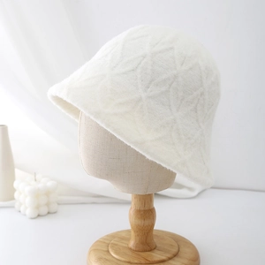Detail of white plush bucket hat featuring a textured diamond lattice pattern and soft fur