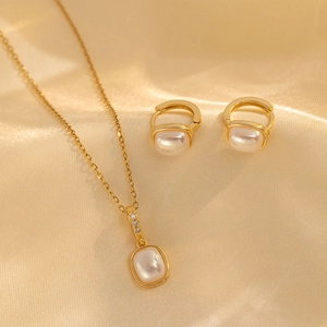 Elegant gold necklace and earrings set with square opal stones on champagne silk
