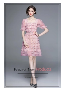 Vue détaillée des volants en dentelle et du tissu mesh rose sur une robe à manches bouffantes