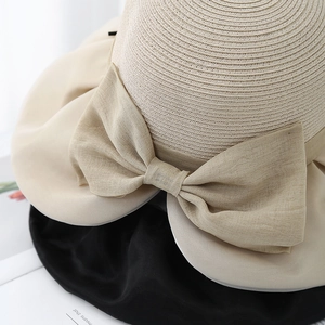 Detailed close-up of woven straw texture with a large decorative beige mesh bow