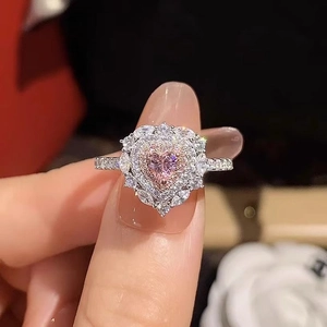 Vista macro di anello in argento con diamante rosa a cuore e pavé di diamanti