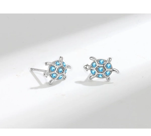 Macro di orecchini a lobo a tartaruga in argento con zirconi blu chiaro su sfondo bianco