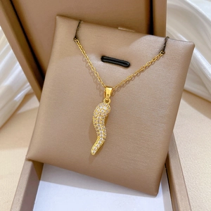 Detailed close-up of a gold-plated chili horn pendant with sparkling cubic zirconia crystals