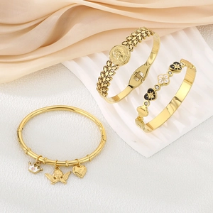 Golden titanium steel bracelet set featuring heart crown pendants on cream silk background