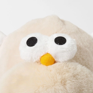 Detail of cute bird eyes and yellow nose on beige faux fur earmuff hat for winter