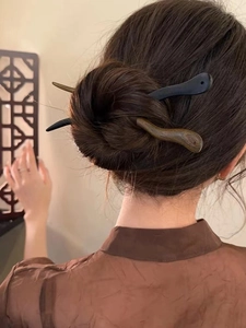 Pics à cheveux en bois classiques présentés sur un chignon avec paravent chinois