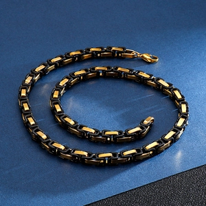 Macro shot of two-tone black and gold square link chain necklace with lobster clasp closure