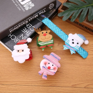 Detailed view of plush Santa and reindeer Christmas slap bracelets on a wooden surface