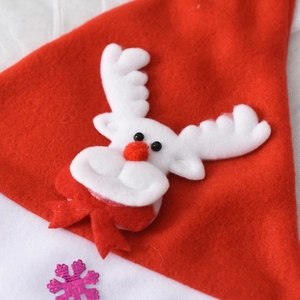 Detail view of a red felt Christmas hat featuring a reindeer appliqué and pink sequins