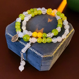 Detailed shot of multi-colored beaded bracelet with Chinese character charm on velvet box