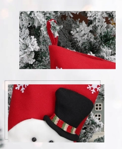 Close-up detail of a red felt Christmas stocking with a black hat and snowflake patterns