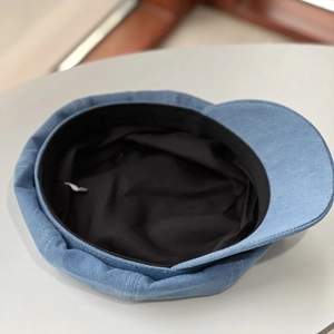Detail view of denim newsboy cap showing black inner lining and sweatband construction