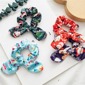 Close-up of four festive Christmas scrunchies with bunny ears and holiday patterns