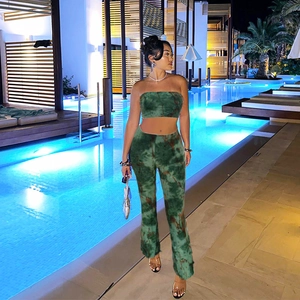 Dettaglio completo di set tie-dye verde con top a fascia e pantaloni a zampa a bordo piscina