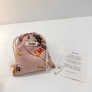 Pink corduroy drawstring pouch with a colorful smile print and a soft ribbed texture