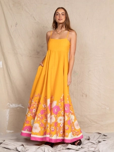Elegant yellow floral maxi dress with thin straps for beach vacations and summer wear