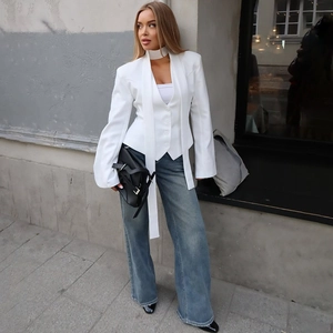Detail of white fashion blazer with side-tie waist and split sleeve cuffs for women