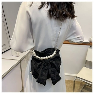 Detailed back view of a black bow-shaped crossbody bag with decorative pearl strap