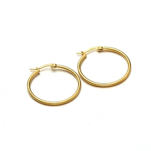 Detail of gold titanium steel hoop earrings featuring latch back closure and polished finish