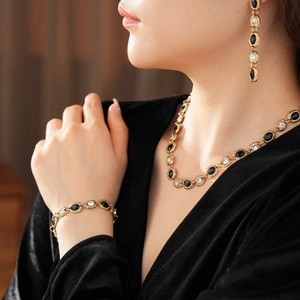 Vue macro du collier et bracelet vintage dorés avec pierres noires sur un mannequin