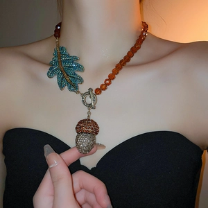 Détail du collier de pignons vintage avec perles ambre et feuille de diamant bleu