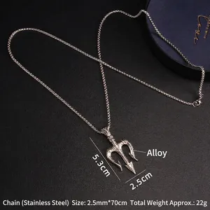 Hip hop trident pendant necklace with stainless steel chain on a black leather surface