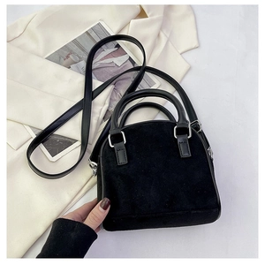 Detail of black suede dome handbag with leather handles and silver hardware