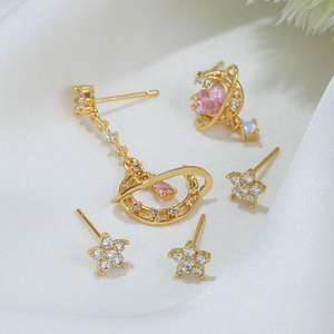 Golden earring set with pink and white zircon stones featuring stars and planet motifs