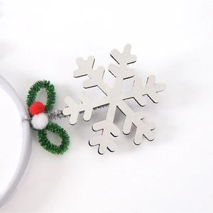 Detail of silver glitter snowflake headband with holly leaves and plush berries for parties
