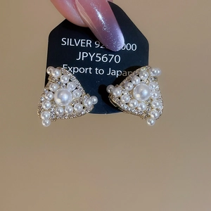 Close-up of geometric triangle pearl earrings with sparkling zircons and S925 silver post