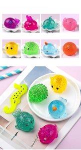 Detail of glitter ocean animal squishy toys featuring a translucent whale and dolphin