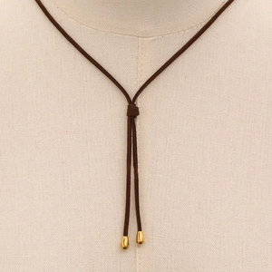 Detail of a brown suede Y-necklace with polished gold metal teardrop pendants