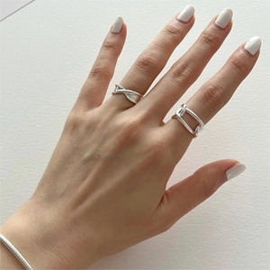 Detailed close-up of 925 sterling silver chain link and twist rings on model's hand