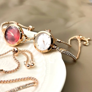 Detail of gold quartz watches with red and white crystal dials and matching bracelet