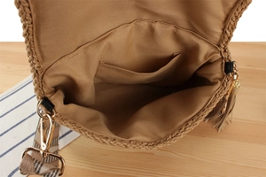 Detail of woven beach bag interior featuring fabric lining and golden metal buckle