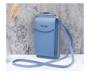Detail of light blue crossbody phone wallet with pebble texture and gold hardware